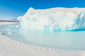 Ice berg on frozen sea in sunshine. Greenland