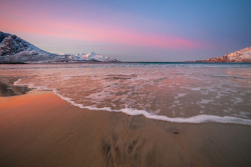 sunrise with amazing magenta color over sand beach and fjord. Tromso, Norway. Winter. Polar night. long shutter speed