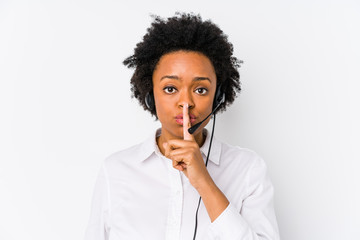 Young african american telemarketer woman isolated keeping a secret or asking for silence.