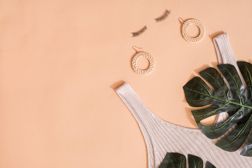 Beauty concept in a blog.Women's summer accessories, false eyelashes.Female background and fashion. Exotic green leaf of palm tree. on a pink background.Fashion or summer holiday concept.Flat lay