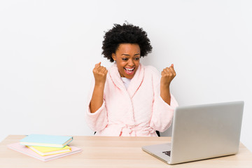 Middle aged african american woman working at home isolated cheering carefree and excited. Victory concept.