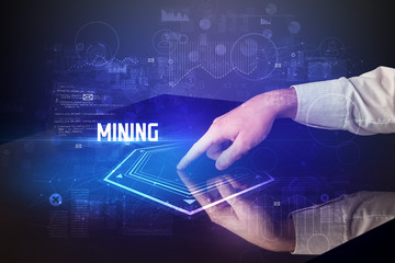 Hand touching digital table with MINING inscription, new age security concept