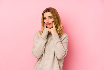 Young blonde cute woman wearing a sweater isolated doubting between two options.