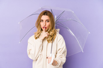 Young blonde woman holding an umbrella isolated Young blonde woman holding an umbrella isolated...