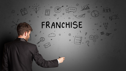 businessman drawing a creative idea sketch with FRANCHISE inscription, business strategy concept