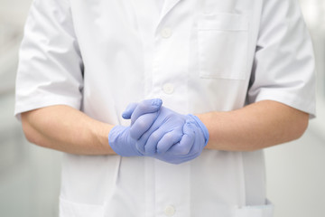 Hands of doctor weared in medical gloves in confident gesture