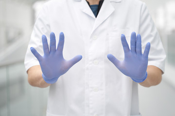 Hands of doctor weared medical gloves in a stop gesture