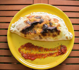 Calzone pizza served on wooden table