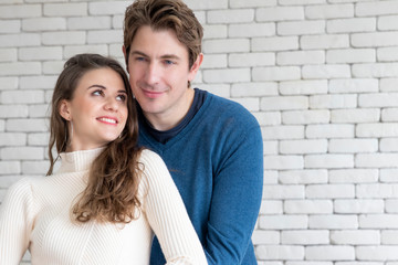Caucasian couple hugging together.