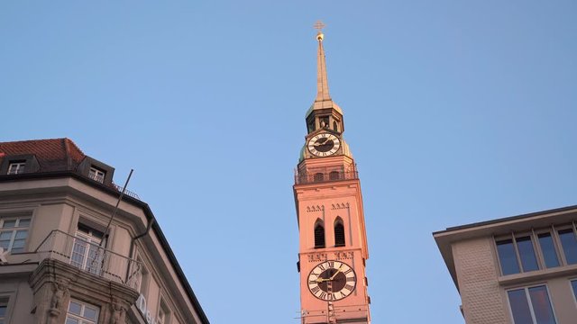 Pan real time shot of the clock tower of St. Peter's Church at sunset time, Munich, Germany