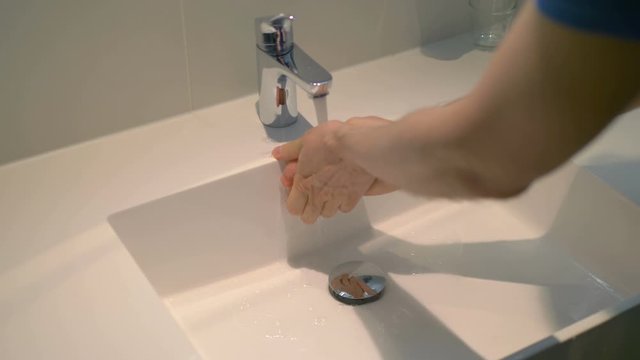 Man washing hands under flowing water from faulty tap in 4K slow motion 60fps - Powered by Adobe