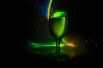 Goblet of white wine on wooden table on wooden wall background