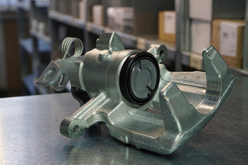 Front brake caliper close-up on a steel background. Original high-quality spare parts for a modern...