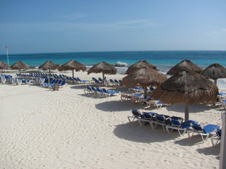 beach with lounge chairs and umbrellas