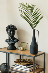 Stylish and floral composition of tropical leaf in modern vases on the design shelf with elegant...