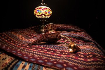 Lamp of wishes concept. Antique Aladdin arabian nights genie style oil lamp with soft light white...