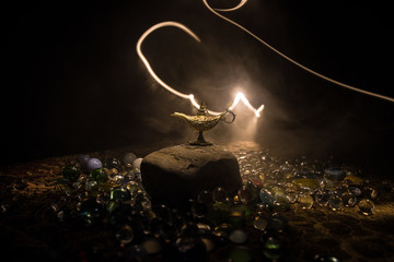 Lamp of wishes concept. Antique Aladdin arabian nights genie style oil lamp with soft light white...