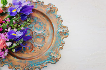 Pesah celebration concept (jewish Passover holiday). Traditional pesah plate text in hebrew: Passover, horseradish, celery, egg, bone, maror, charoset