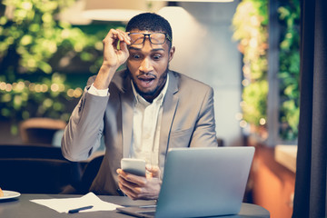 Black business guy sees shocking sms using cellphone