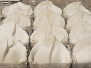 Close up of raw fresh frozen dumplings in plastic box. Boiled dumplings are traditional Asian homemade food. Taiwan food. Could be background.