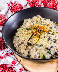 A serving of Mushroom Risotto in a dark round bowl, surrounded by a red and white cloth and red love heart shaped  string lights.