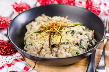 A serving of Mushroom Risotto in a dark round bowl, surrounded by a red and white cloth and red love heart shaped  string lights.