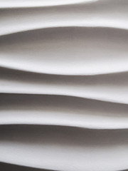 Abstract background formed by smooth wavy lines of gypsum on the wall. The difference of lights and shadows.