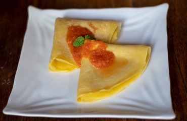 Breakfast pancake served on the table with tomato sauce in a white plate for tourists in Bali