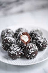 Petit fours mini pastries on white marble background with copy space