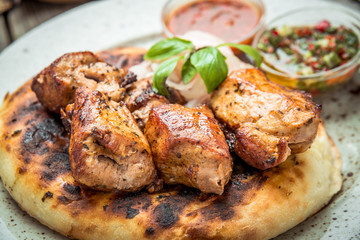 two pieces of of grilled pork with herbs on a paper