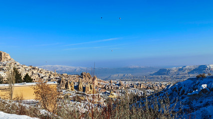Fototapeta na wymiar Pigeon valley with snowy landscape in winter in Cappadocia, Turkey
