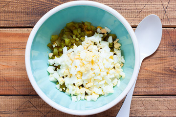 Step by step preparation of salad with canned tuna and corn, step 4 - adding chopped boiled eggs to the salad, top view, horizontal