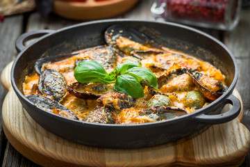 mussels with cheese sauce, in a frying pan