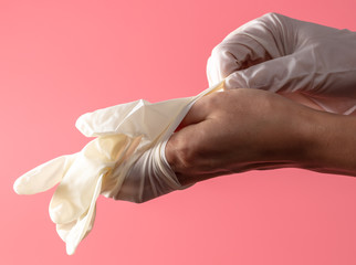 The doctor puts on medical gloves