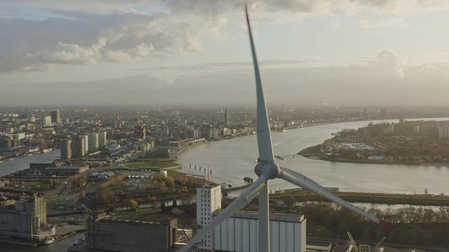 Antwerp Belgium Aerial v38 Flying around wind turbines in industrial area with cityscape views at sunset - November 2019