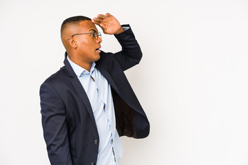 Naklejka premium Young business latin man isolated on white background looking far away keeping hand on forehead.