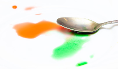 Red and green paint on a white plate.
