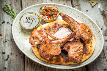 two pieces of of grilled pork with herbs on a paper