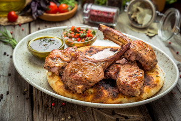 two pieces of of grilled pork with herbs on a paper