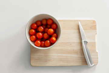 A bowl of cherry tomatoes on a cutting board. Cooking healthy and tasty food