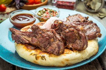 two pieces of of grilled pork with herbs on a paper