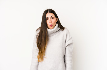Young caucasian woman isolated on a white background shrugs shoulders and open eyes confused.