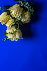 bouquet of yellow artificial flowers on a blue background