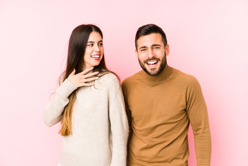 Fototapeta premium Young caucasian couple isolated laughs out loudly keeping hand on chest.