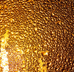 Капли воды на стекле в золотых лучах солнца.