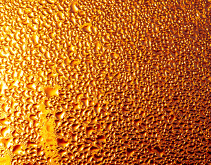 Капли воды на стекле в золотых лучах солнца.