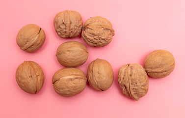 Walnuts on a pink background.