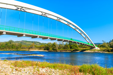 Obraz premium Bridge over Dunajec river and Velo cycling road, Beskid Sadecki Mountains, Poland