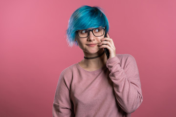 Woman with blue hair talking with somebody by mobile phone. Girl smiling, having pleasant conversation. Technology, mobile connection concept.