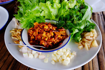 Thai Cuisine Smoked shrimp chili dip with vegetables and garlic on white dish